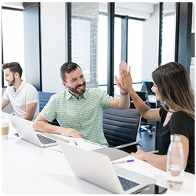 Two people at table high-fiving - HealthStream